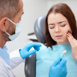 Beautiful young woman visiting dentist for medical checkup Acil Diş Tedavisi